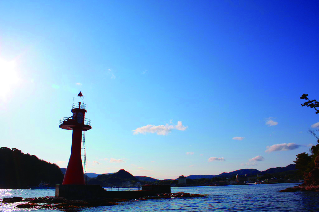 晴天のもと、灯台がそびえる間口の写真