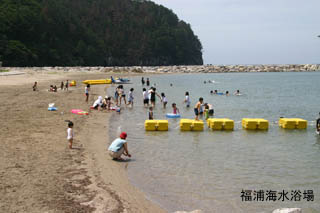 テトラポッドと黄色のブイで海水浴エリアが区切られている福浦海水浴場の写真
