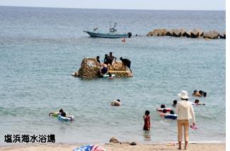 広い海を背景に、海水浴客でにぎわう塩浜海水浴場の写真