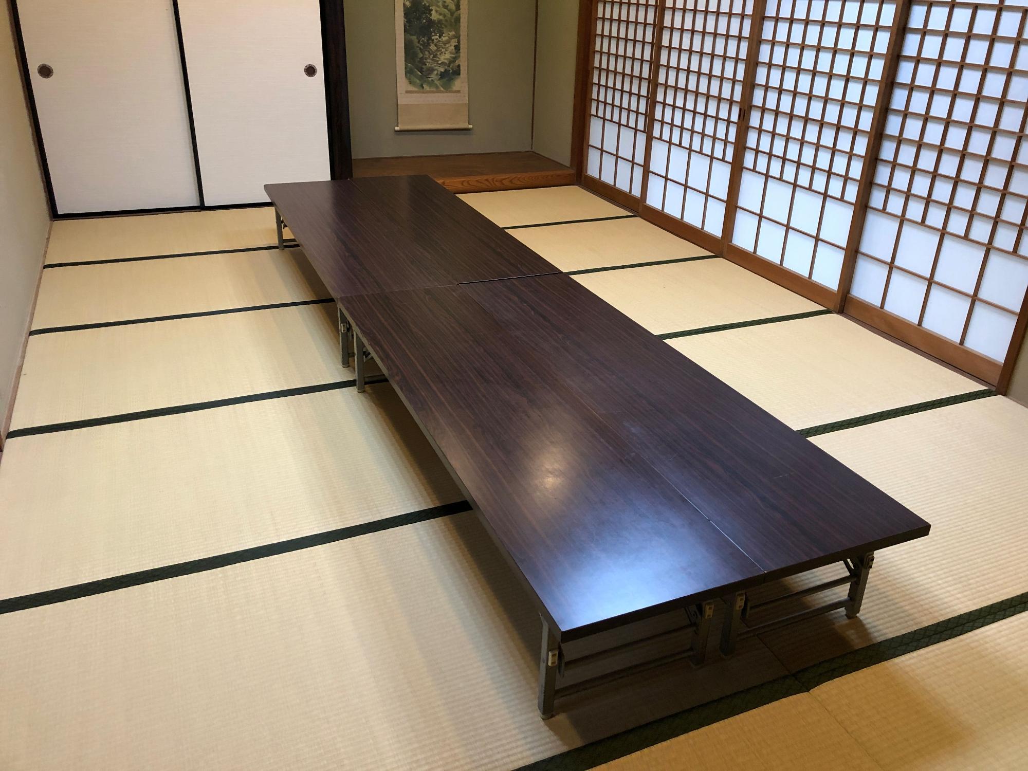 畳の部屋に長いテーブルが置かれている教養娯楽室の写真