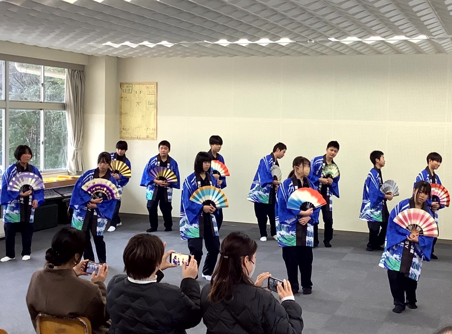 地域後悔の参観日があり、発表を行う1年生生徒の様子。扇を回して、ゆったりと踊っている。