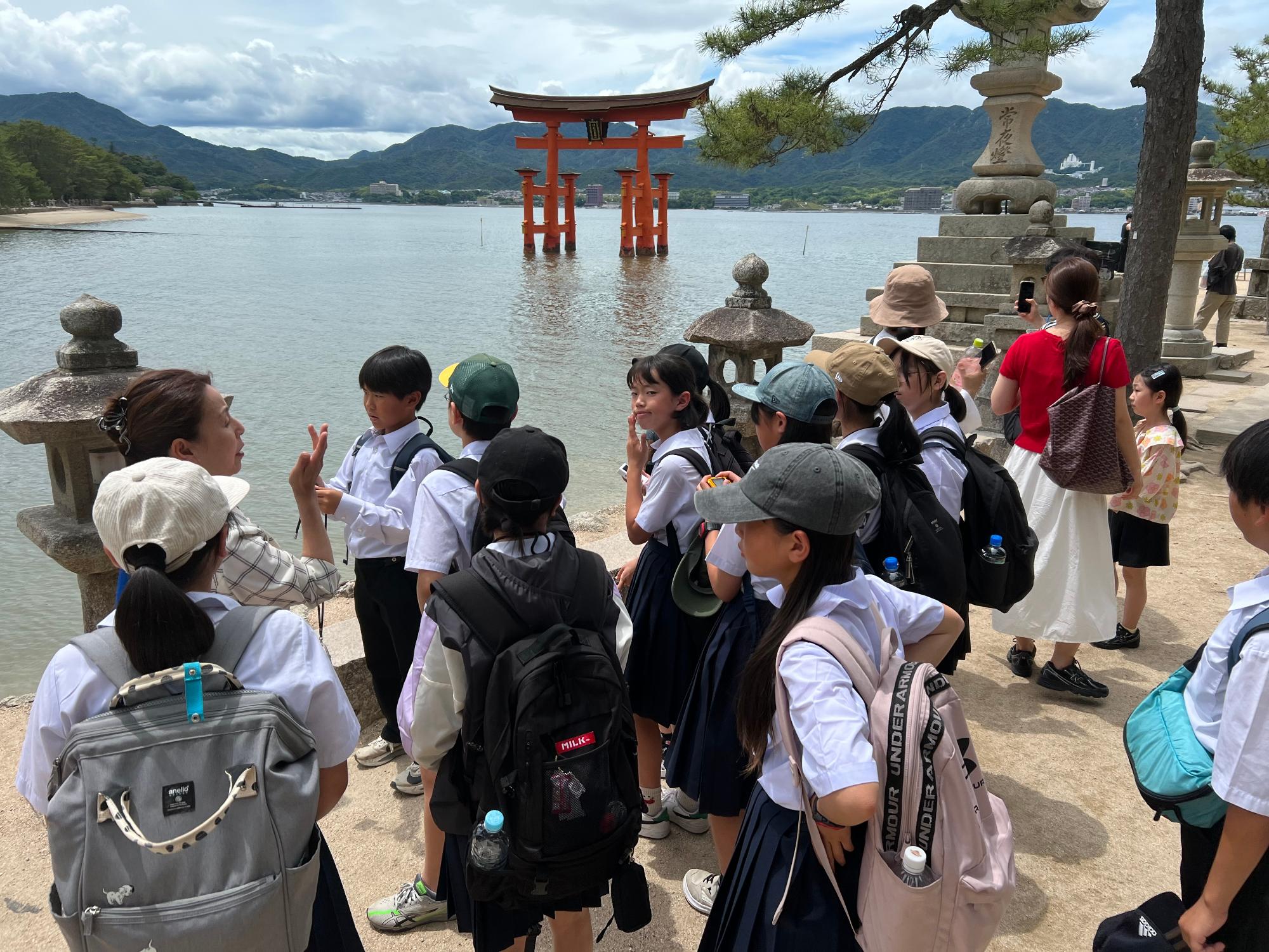 宮島の厳島神社の鳥居を見る児童たち