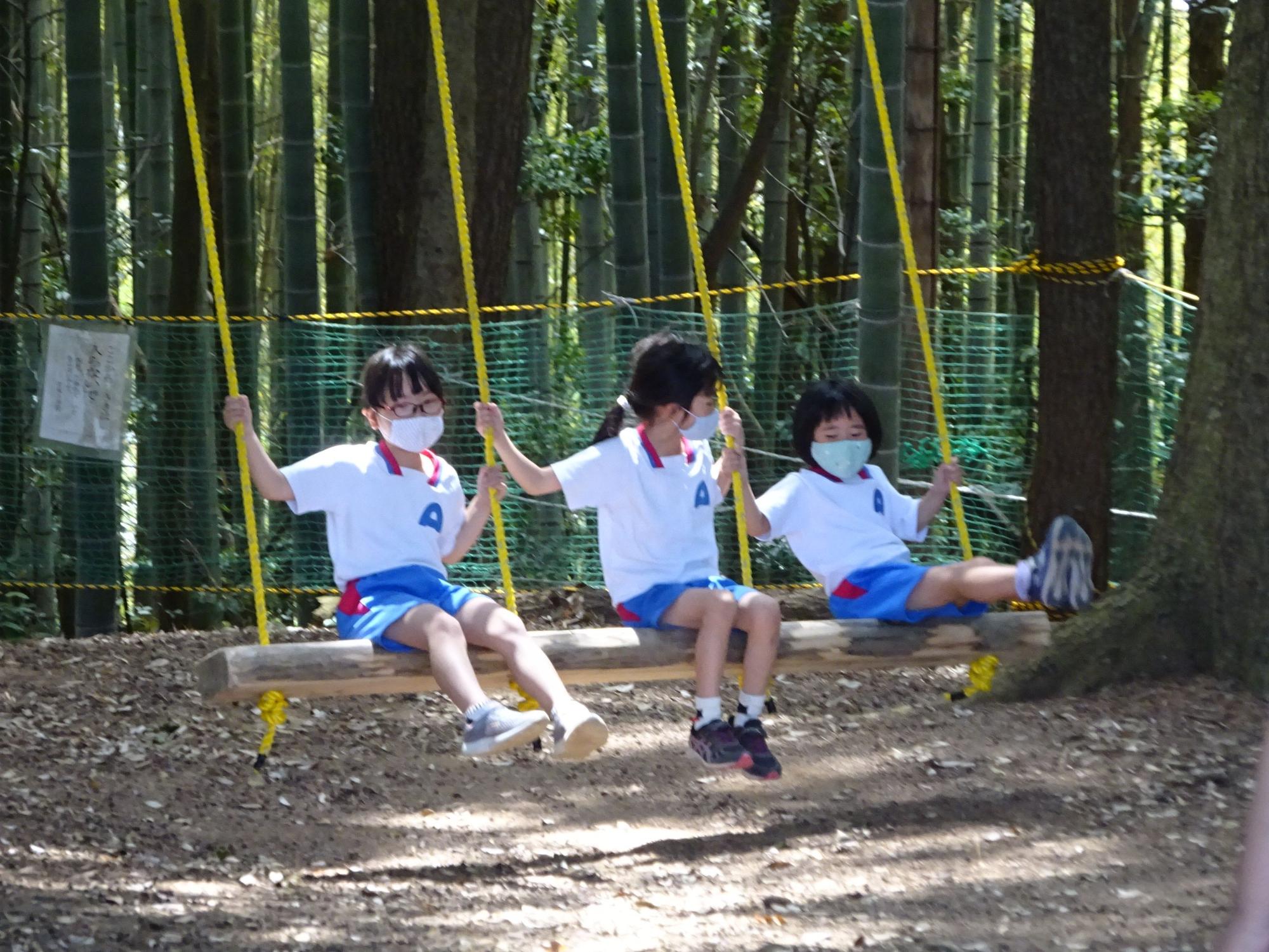 竹林でブランコをこぐ子どもたちの写真