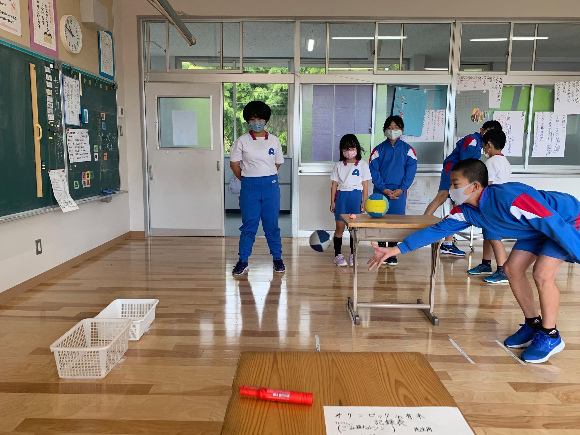 教室で白いかごにボールを投げ入れるゲームに挑戦する生徒の写真