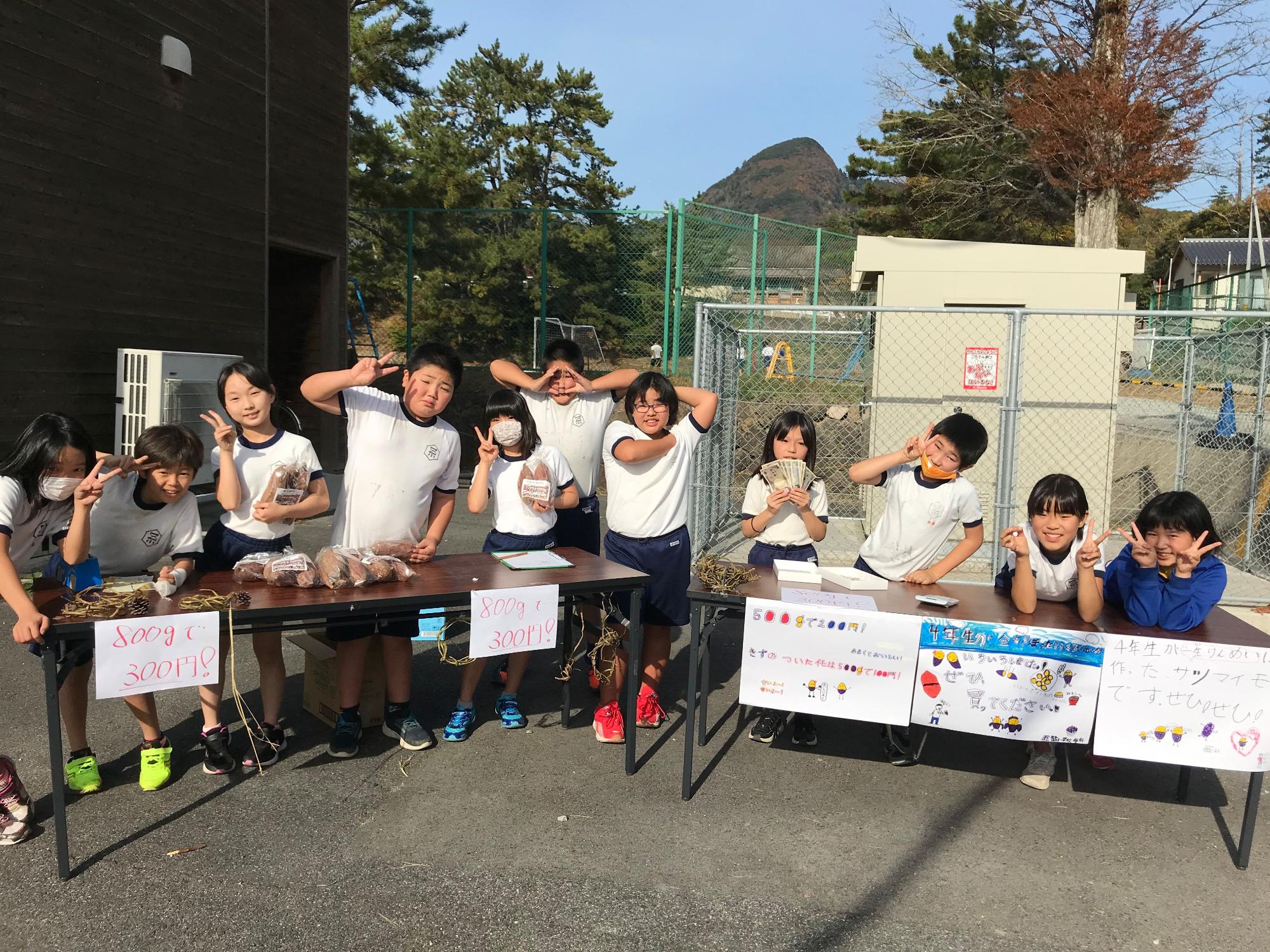 笑顔でピースサインを作って、横に並んで立っている児童たちの写真