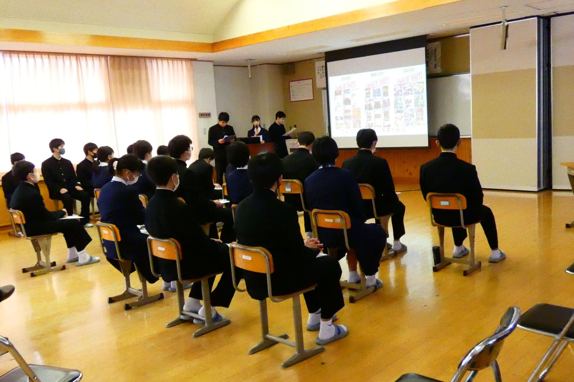 教室で座って発表を聞く生徒たちの写真