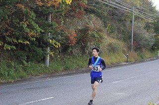 道路沿いを青いゼッケンの生徒が力走している写真