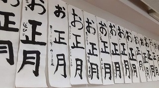 壁に並べて展示された「お正月」と書かれた書き初め作品の写真