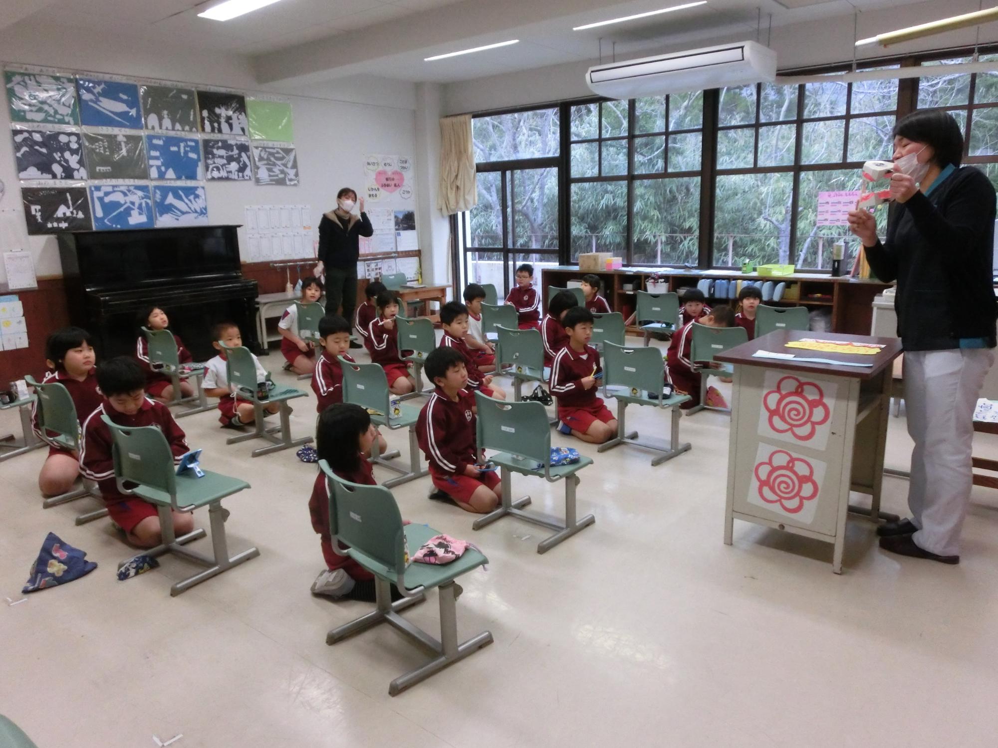 体育館で委員会の児童4人が活動目標のポスターを掲げている写真