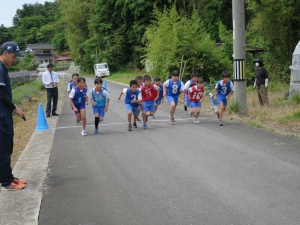 外で児童たちがマラソンのスタートダッシュを行っている様子の写真