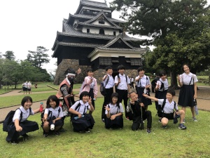 島根の建造物の前で児童たちが記念撮影を行っている写真