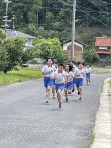 外で児童たちがマラソンを行っている様子の写真