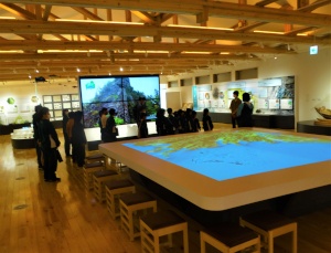 展示施設で児童たちが大型模型を見学している写真