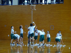 体育館で児童たちが玉入れをしている写真