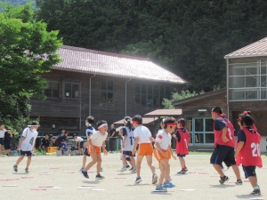 校庭で児童たちが赤白に分かれて試合をしている写真
