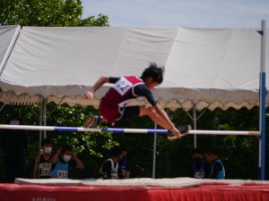 陸上大会で男子児童が走り高跳びをしている写真