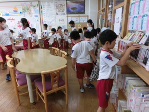 図書室で児童たちが本を選んでいる写真