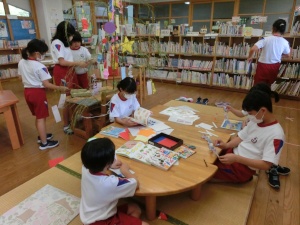 図書室で児童たちが七夕飾りを作ったり、本を読んだりしている写真