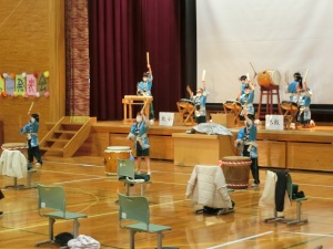 体育館で児童が和太鼓を演奏している写真