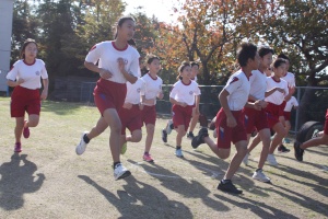 校庭で児童がマラソンをする写真