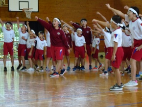 体育館で赤組の児童が応援をする写真