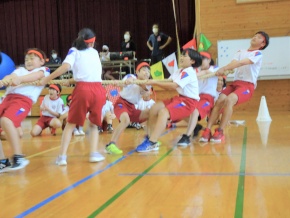 体育館で児童が綱引きをする写真