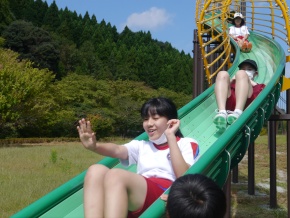 公園で児童が滑り台で遊ぶ写真