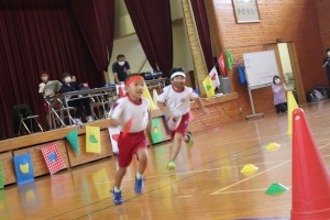 体育館で児童がリレーで走る写真