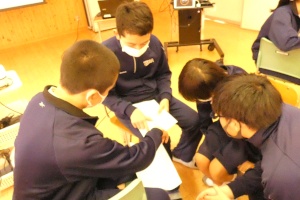 教室で生徒たちがしゃがみ込み意見を出し合う写真