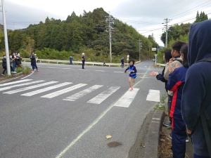 沿道で生徒たちが走者を応援する写真