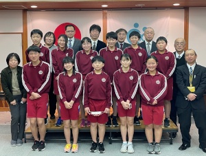 式典会場で6年生と教員が並んで記念撮影をしている写真