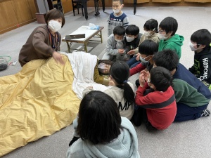 室で講師の説明を聞きながらバースデープロジェクトの講習をを受ける児童たちの写真