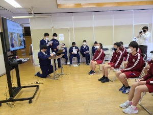 教室でモニターを見ながら発表を聞く児童たちの写真