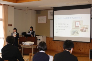 椅子に座った生徒たちの前で、スクリーンに移した資料を使いながら発表を行う2人の女子生徒の写真