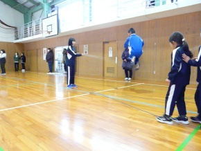 児童二人が回す大縄跳びに入って一人の児童が飛んでいる様子の写真