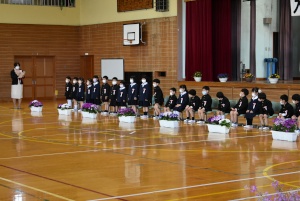 体育館の前列で新入生の児童たちが整列して入学式に臨んでいる写真