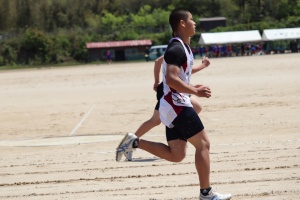 グラウンドのトラックの上を2人で並んで走っている写真