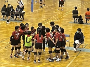 体育館で手を出して円形になり気合を入れている生徒たちの写真