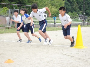 校庭でスタートラインに並んで走り出す児童たちの写真