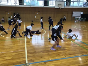 体育館の中央で児童たちが体操をしている写真