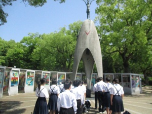 平和記念公園で慰霊碑を見上げる生徒たちの後ろ姿の写真