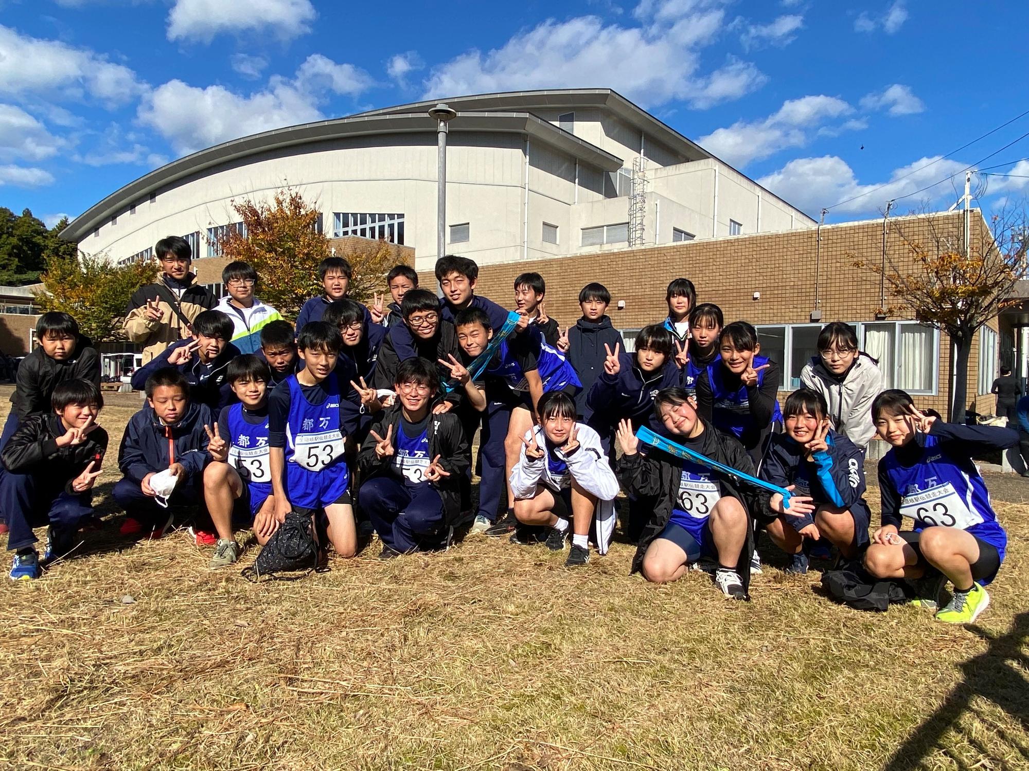 芝生の上にゼッケンをした男女が並んで集合している写真