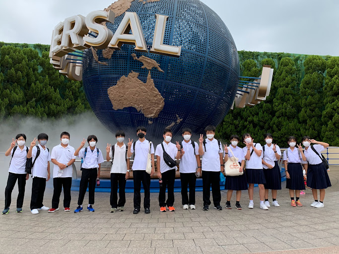 ユニバーサルスタジオジャパンの入り口で生徒が横に並び集合している写真