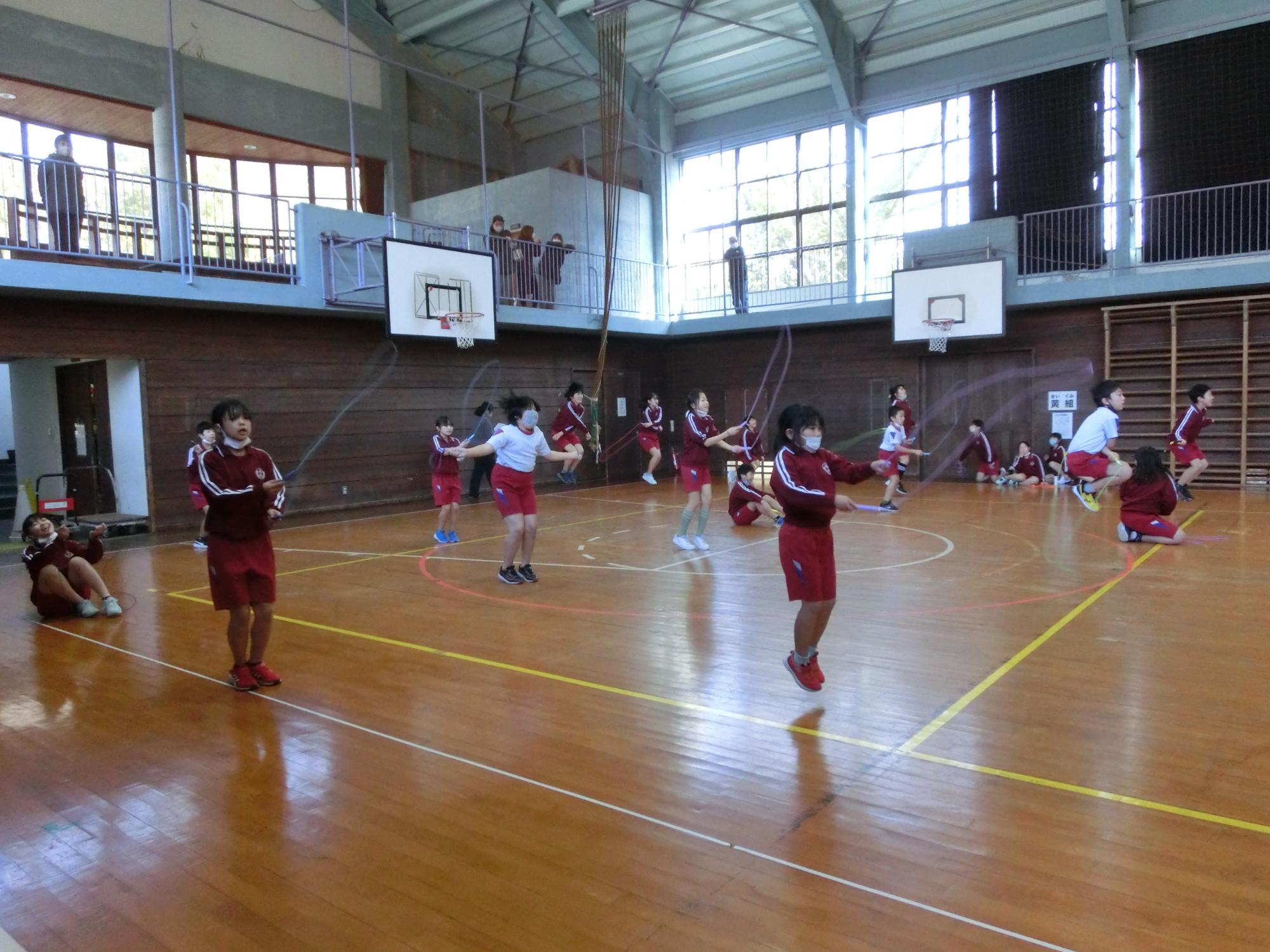体育館で児童たちが個人縄跳びをしている写真