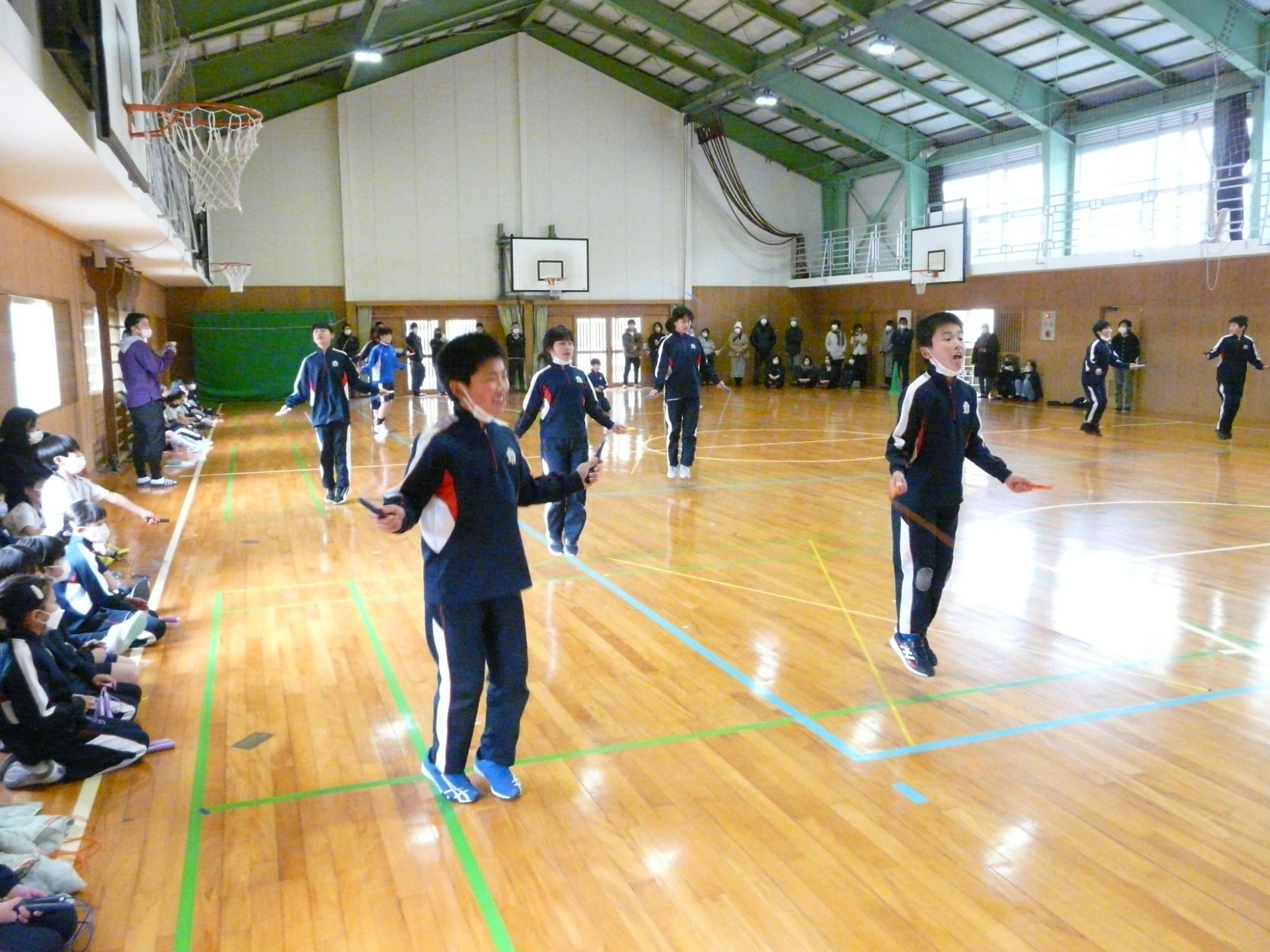 体育館で児童が縄跳びを飛んでいる最中の写真