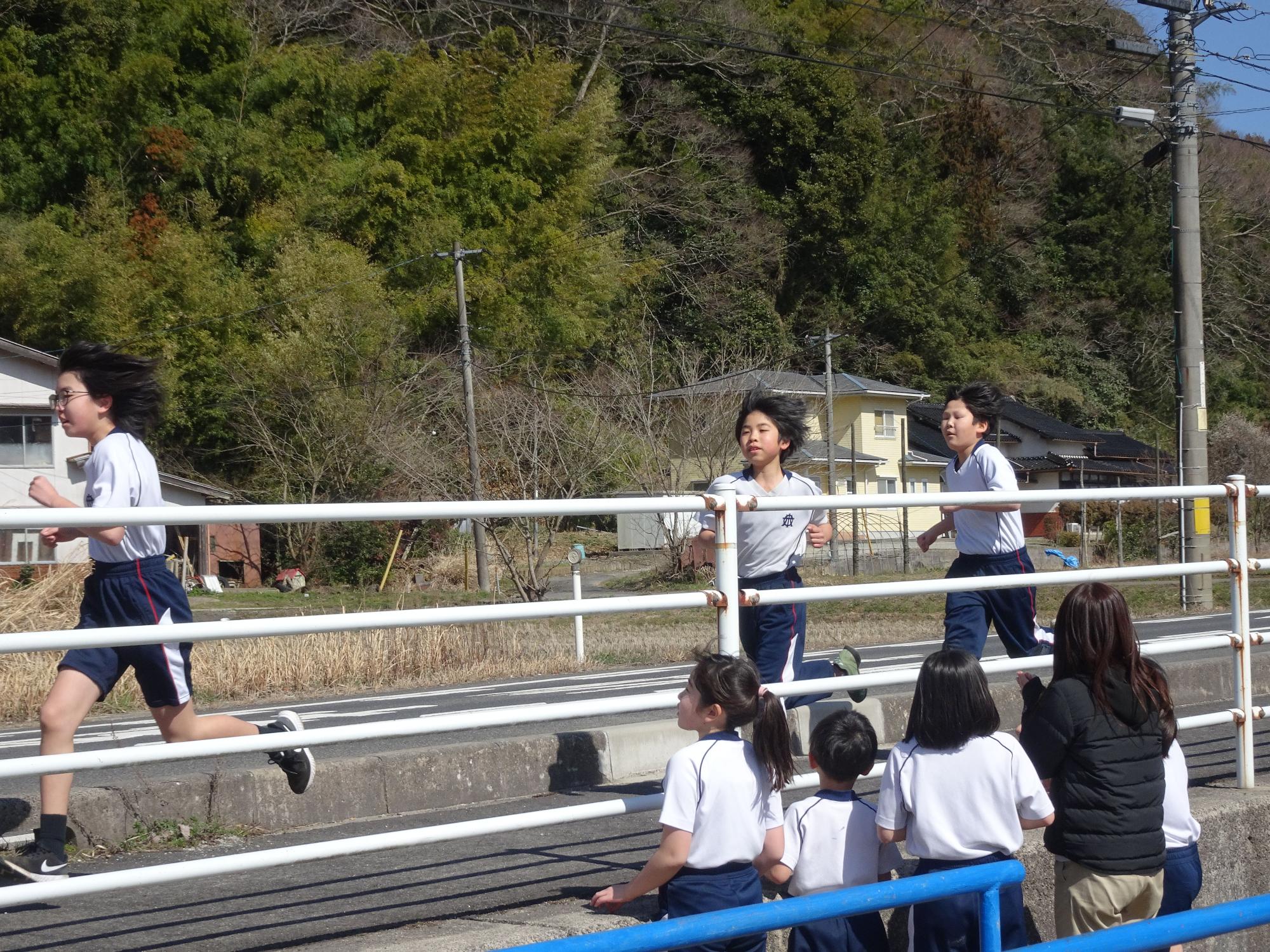 道路を走る体操着姿の女子児童たちの写真