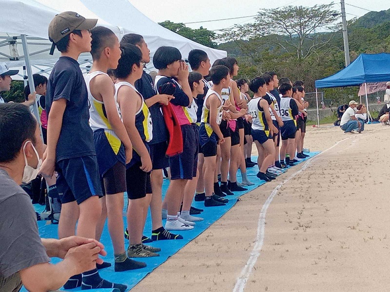コース脇で横一列に並び仲間の走りを見守る児童たちの写真