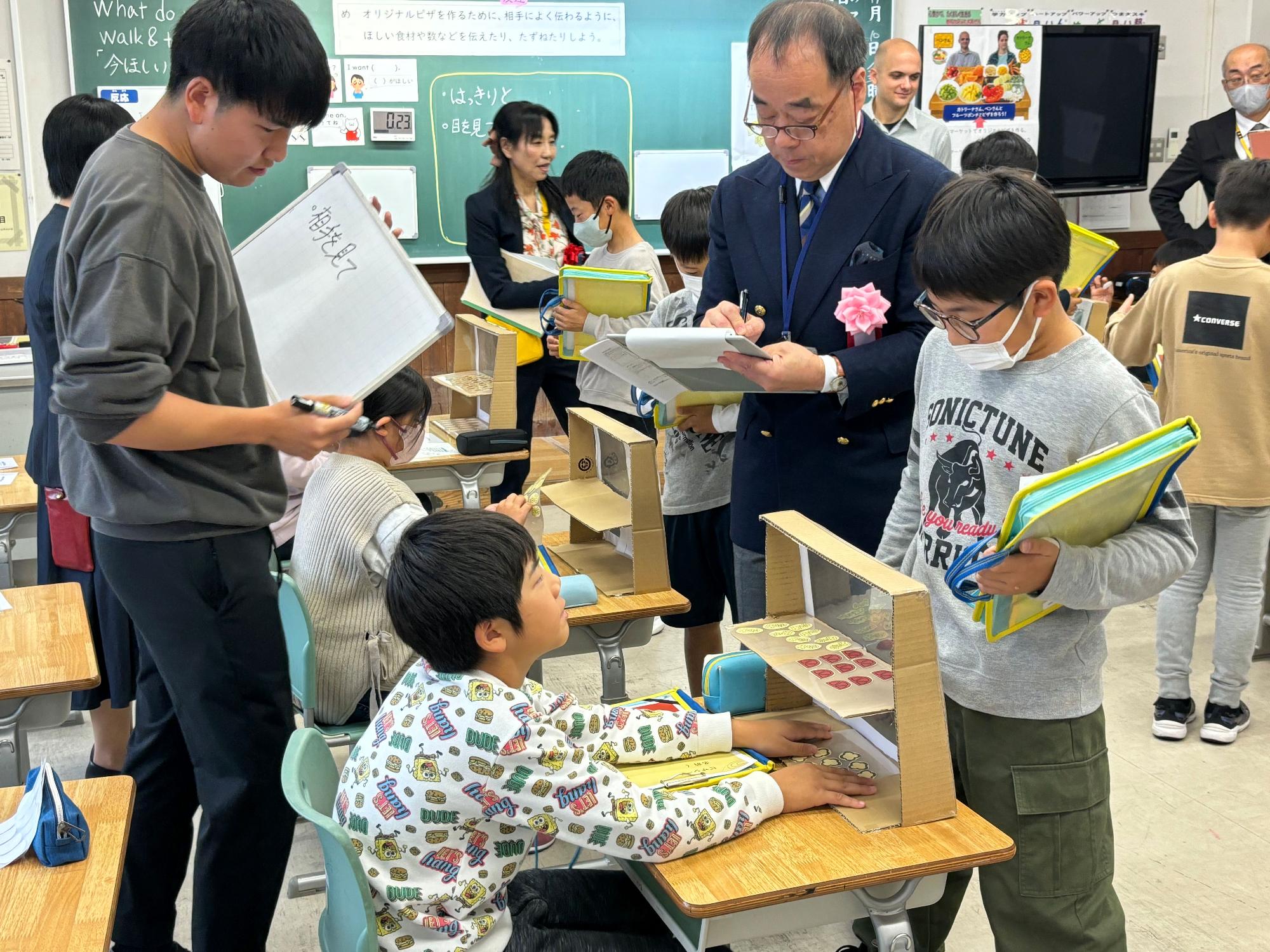 授業中の教室で児童と先生が一緒に活動している写真