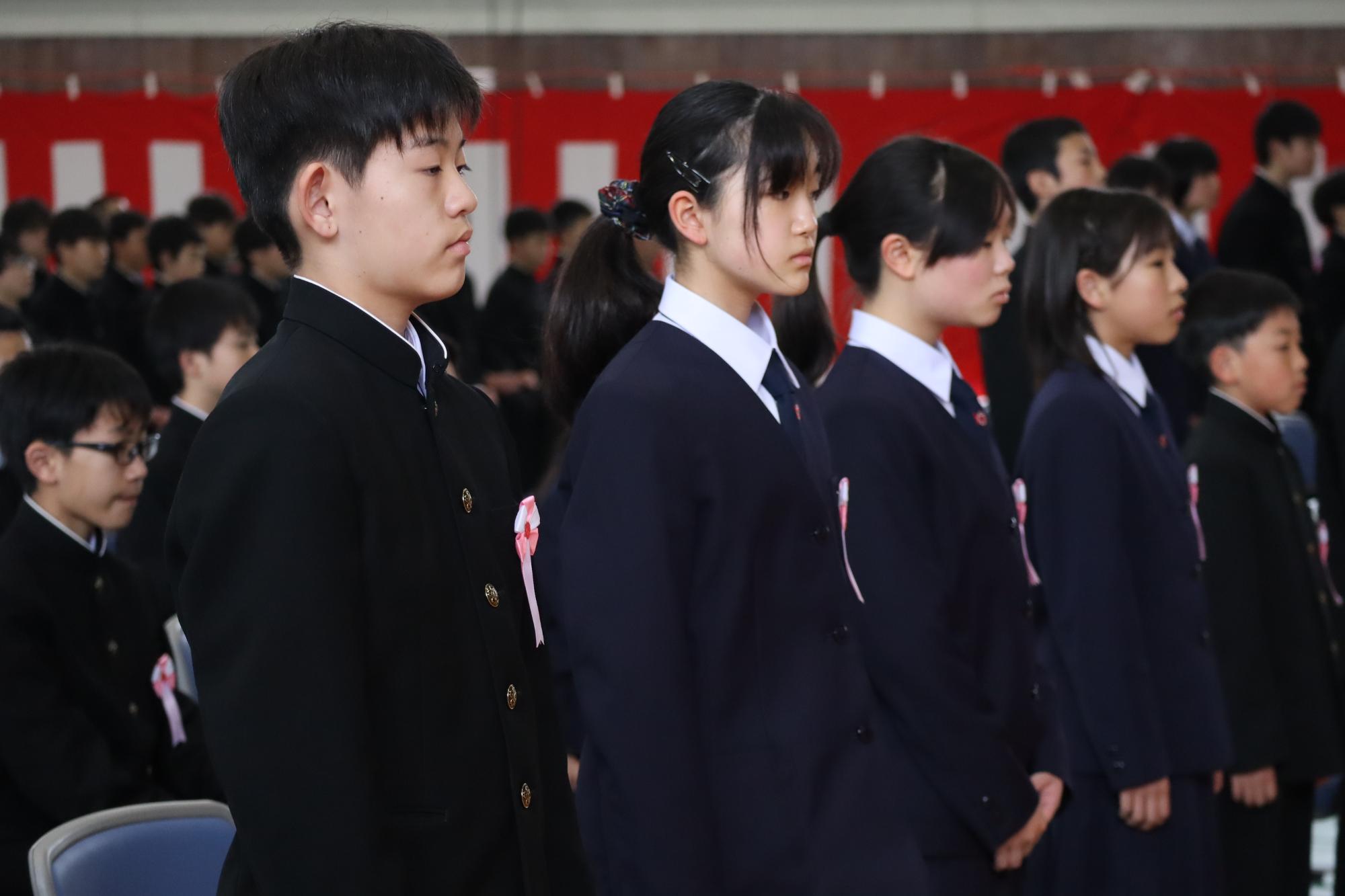 体育館で新入生の生徒たちが入学式に臨んでいる写真