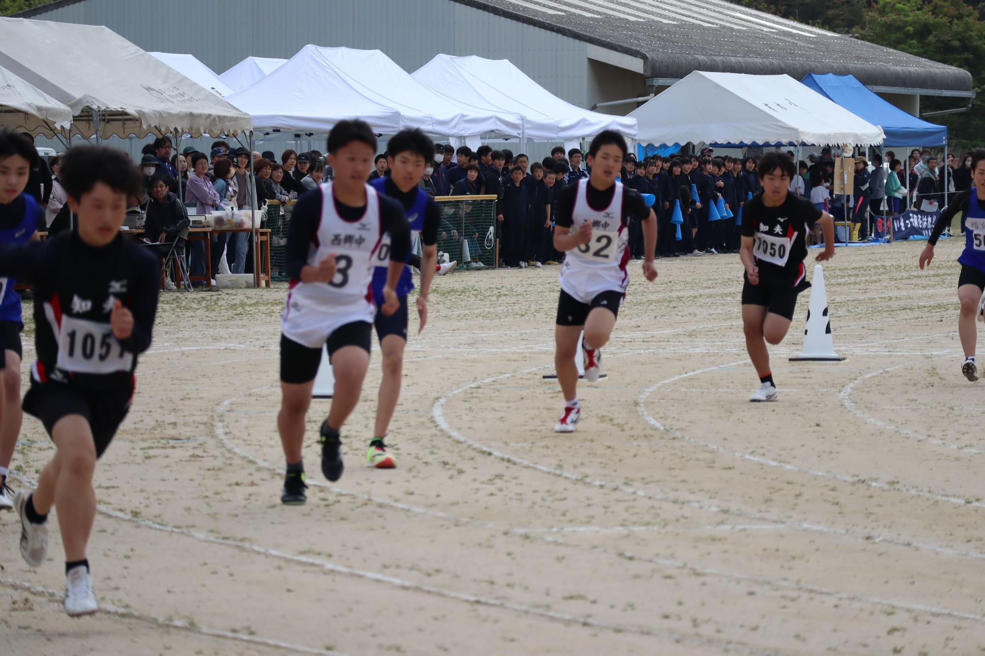 運動場で男子生徒たちが、陸上競技をしている写真